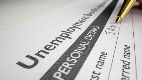 Completing unemployment benefits application form with placeholder name, shot with macro probe lens