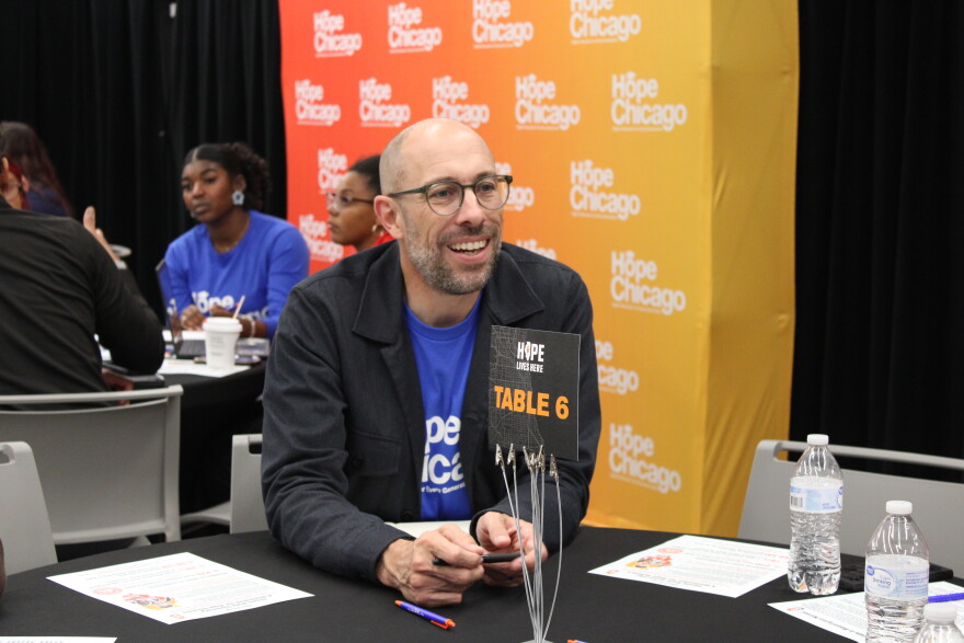 Hope Chicago CEO Aaron Kuecker sitting at a table, talking with students.