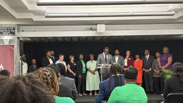 A crowd sits facing Birmingham Mayor Randall Woodfin and other city leaders at a press conference unveiling the city's 5-year strategic plan to reduce violence.