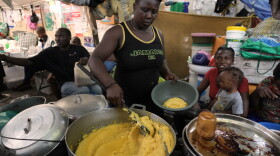 FILE - A woman sells food at a shelter for families displaced by gang violence in Port-au-Prince, Haiti, Aug. 17, 2026.
