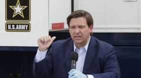 Florida Gov. Ron DeSantis, gestures as he speaks during a news conference in front of a U.S. Army Corps of Engineers mobile command center at the Miami Beach Convention Center, Wednesday, April 8, 2020, in Miami Beach, Fla.