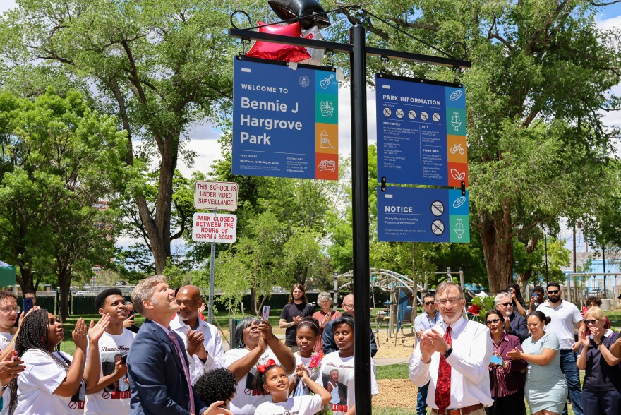 Albuquerque Mayor Tim Keller (left) alongside Bennie Hargrove's family unveil the new park sign bearing his name