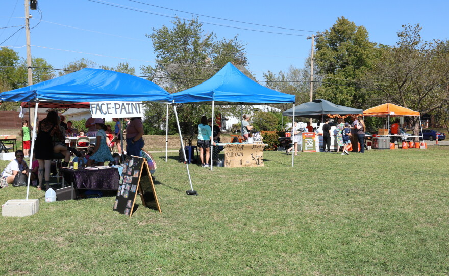 Four tents are set up for kids activities in the neighborhood park at Porchfest. The activities include face painting, designing your own button and builder workshops from Home Depot.