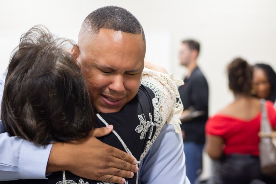 Brock Booker gets a hug from friend Sabrina Shoemaker after his selection to the Wichita Board of Education on Friday.