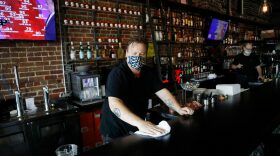 Zack Vermes a bartender at Carmines Ybor Italian restaurant wipes off the bar while awaiting patrons on June 26, 2020 in Tampa, Florida.