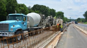 Workers build concrete barriers along I-77 north of Charlotte, as part of the I-77 Express Lanes project. 