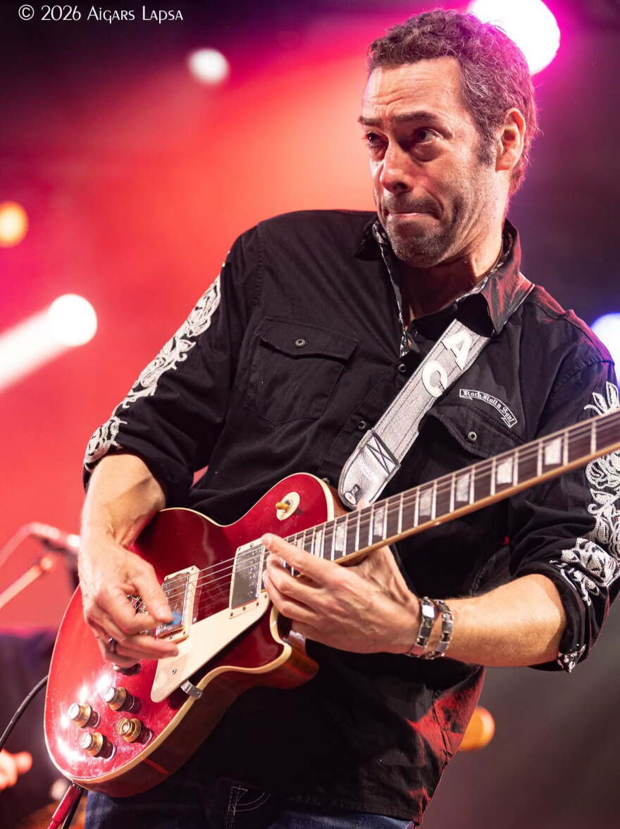 Man plays guitar on stage.