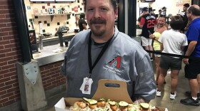 Stephen Tilder, the executive chef at Chase Field in Phoenix, holds the SI Cover Dog, a collaboration with a <em>Sports Illustrated</em> reporter.