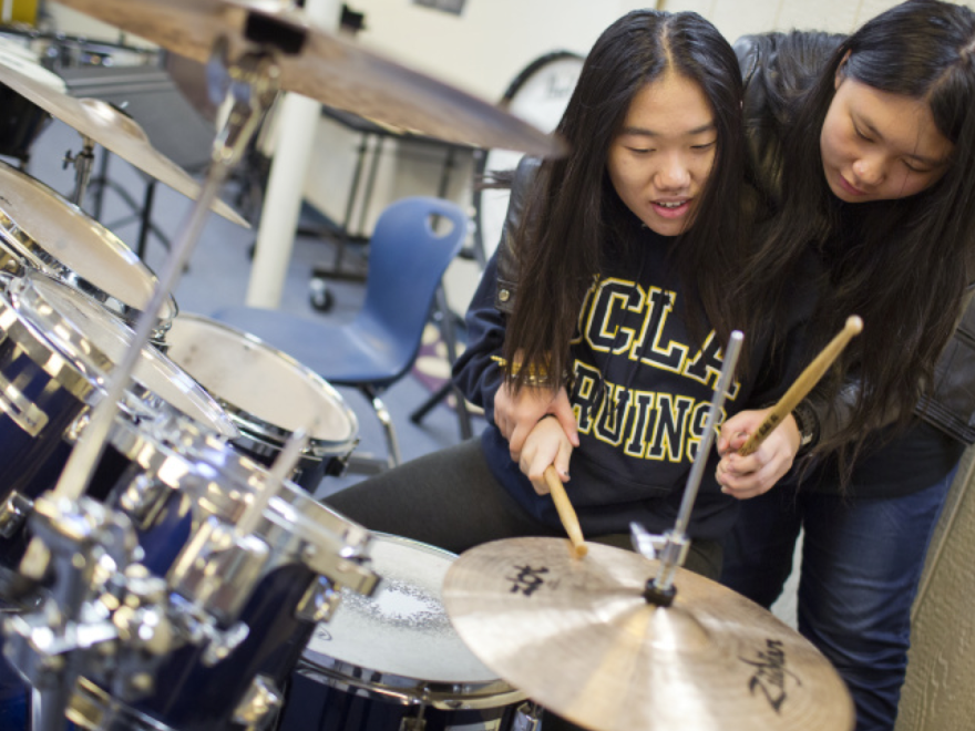 Seventeen-year-old Amber Zhang learns to play drums from freshman Ashley Li at Arroyo Pacific Academy in Arcadia.