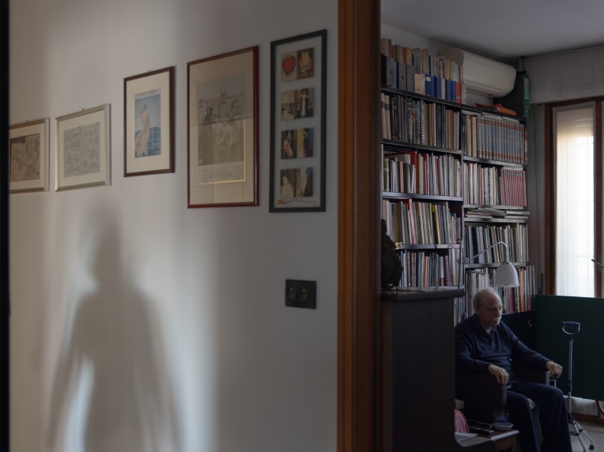 Caregiver Maria Oleksiivna Fedoryshyn's shadow appears as she goes to the kitchen to prepare the lunch for Tommaso, the man she cares for, in Bologna, Italy, in December 2022. Maria was vital in supporting Tommaso and his family when he returned from the hospital after he had a stroke, helping him recover and supporting his wife and son. Maria has lived in Italy for 20 years.