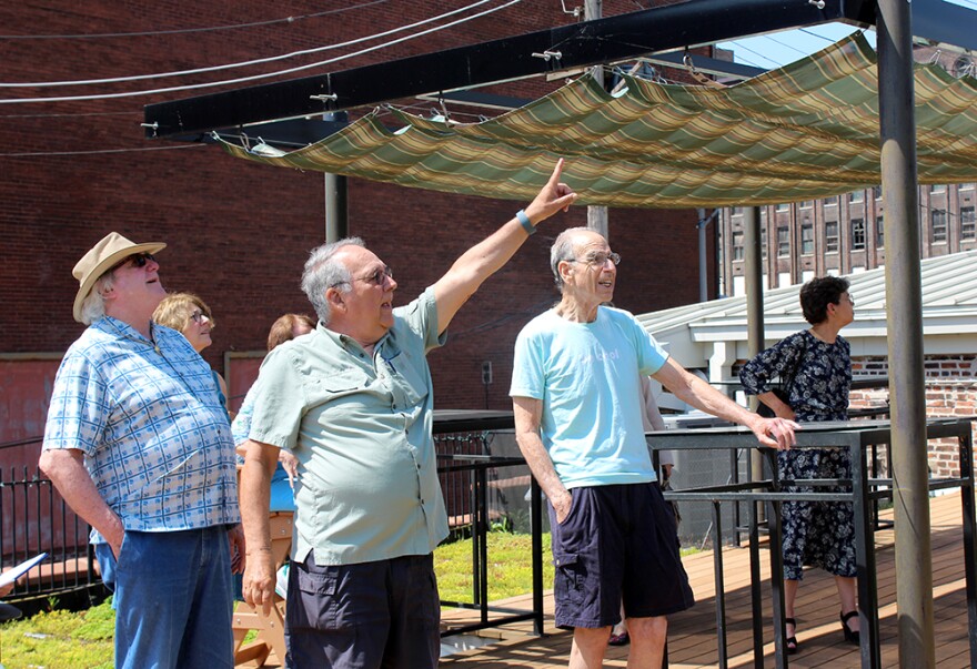 John Sweet, trustee of the William Kerr Foundation points out one of the wind turbines on the roof of the foundation's renovated building on Saturday, June 6, 2015.