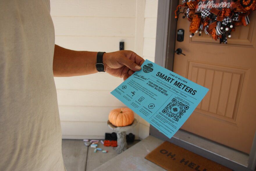 Milliken resident Derek Lucero holds up a blue flyer announcing the app that was created for him to monitor his water usage on his new smart meter. It says in part, "Town Of Milliken Smart Meters. Good news! Your home now has a smart water meter!"