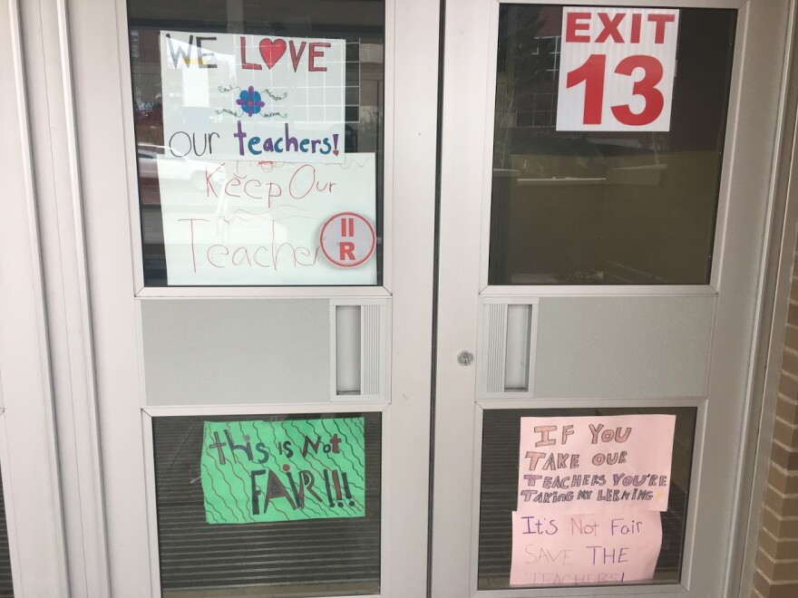 Signs supporting teachers in the wake of mid-year layoffs cover the front doors and windows at Anna Murray Douglass School #12