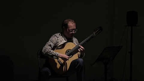 Guitarist Jamie Monck performing in a dark room