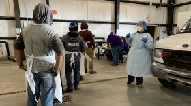 Laura Cobian, a registered nurse with Klamath Health Partnership, speaks with farmworkers waiting to be tested for COVID-19.