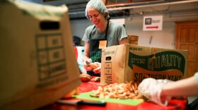 A volunteer peels sweet potatoes.