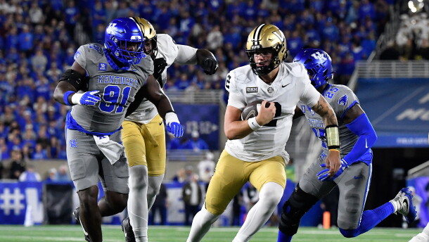 Vanderbilt quarterback Jared Curtis (2) is chased by Kentucky defensive lineman Jaden Williams (91) as he runs through an opening in the defensive line during the first half of an NCAA college football game in Lexington, Ky., Saturday, Oct. 24, 2026. (AP Photo/Timothy D. Easley)