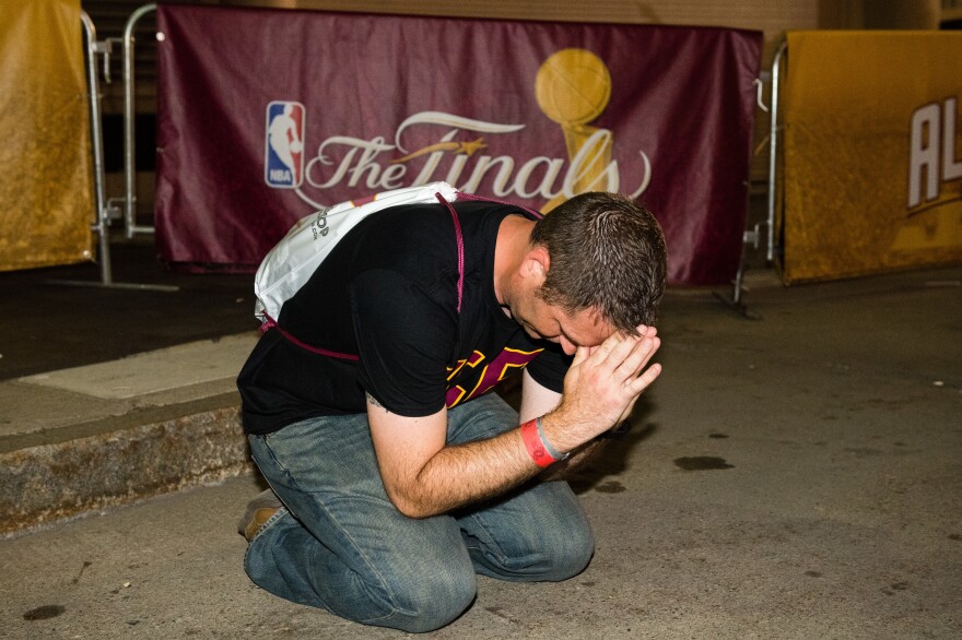 Cleveland fan Brian Wilson says a prayer during the final seconds of the game at the Cleveland Cavaliers NBA Finals Game Seven watch party at Quicken Loans Arena.