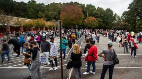 Hundreds of people wait in line for early voting on Monday, Oct. 12, 2020, in Marietta, Georgia. Eager voters have waited six hours or more in the former Republican stronghold of Cobb County, and lines have wrapped around buildings in solidly Democratic DeKalb County. (Ron Harris/AP Photo)