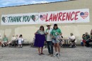 (From left) Laurie LaCour, Nez Perce Tribe and Confederated Tribes and Bands of the Yakama Nation; Stan Herd, Lawrence earthwork artist who created the Algerian flag on the Lied Center lawn of KU; and Jennifer Lewis, White Mountain Apache Tribe, pose in front of the “Thank You Lawrence” sign created and donated by Algeria supporters attending the team’s final block game with Austria at Arrowhead Stadium.