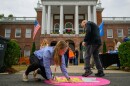 Mackenzie Coburn, the Sales Innovation Manager at Eastern States Exposition, smooths out a Big E promotional decal in front of the fair’s Connecticut hall while printer John Barrow uses his foot. In replying to a question about knowing people were walking on his art, Barrow said, “That's the type of material it's made for. It's got a foil backing to it, and it's, it's a little pebbly, so people can't trip unless they're left footed, like I am.”