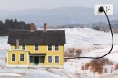 A picture collage of a snowy landscape with an old yellow house plugged into an outlet.