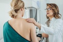 This stock photo shows a female doctor talking to a patient who is there to get a mammogram.