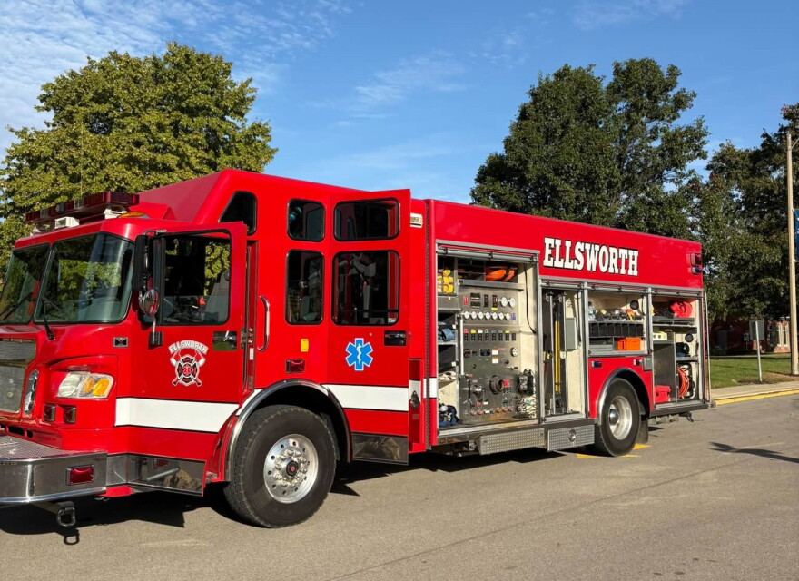 Red Ellsworth fire truck parked with its side equipment compartment open.