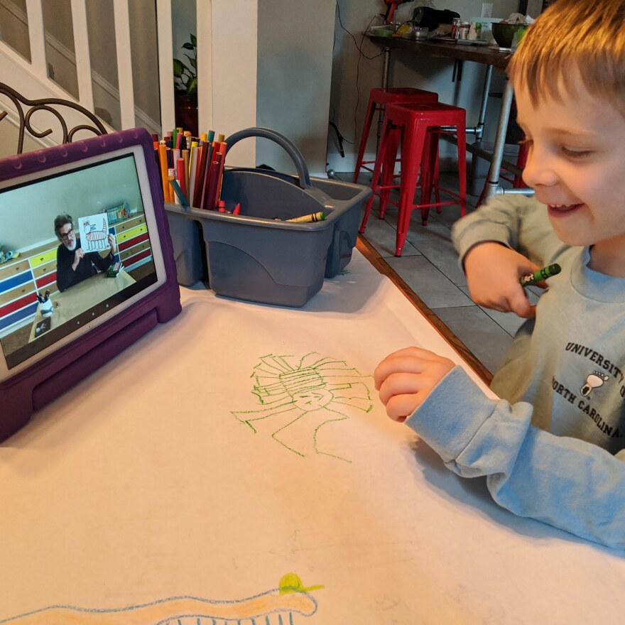 Amy Scott's son, Patrick, follows along with a drawing video by children's author and illustrator Mo Willems.