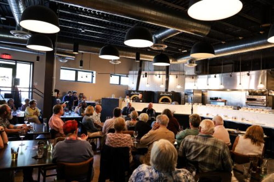 A wide shot showing Ray and Rocco and a full house of guests