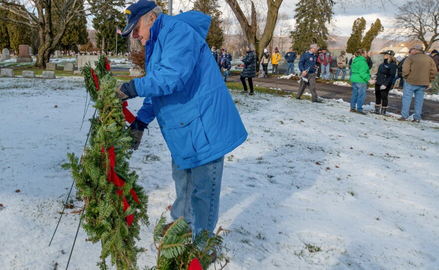 Bruce Biehner adjusts a wreath honoring those who served in the Coast Guard.