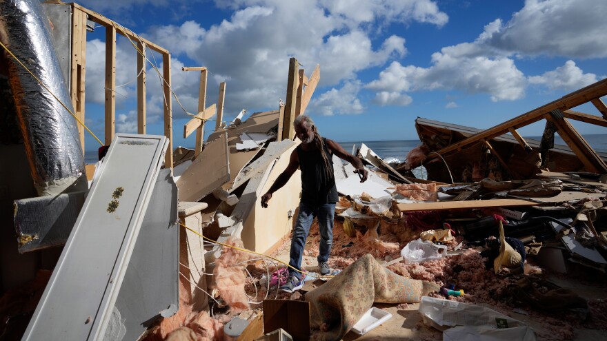 Family friend Tony McDavid walks through the wreckage of the beachfront home of Nina Lavigna, as friends help recover salvageable belongings after half of her house collapsed following beach erosion from Hurricane Nicole, Saturday, Nov. 12, 2022, in Wilbur-By-The-Sea.