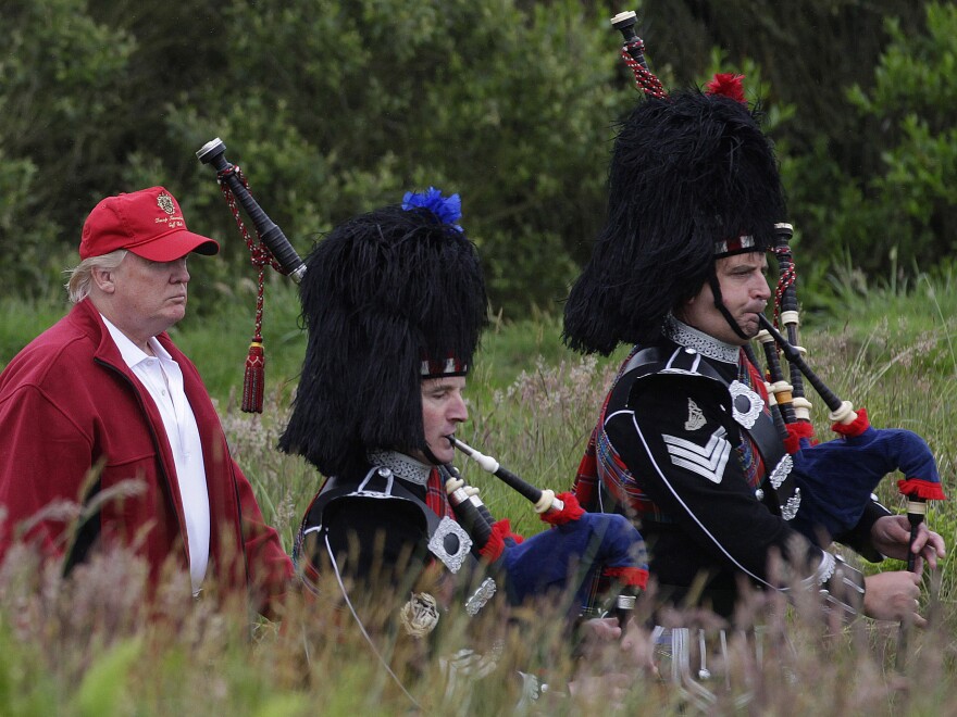 Trump, left, follows bagpipers to the opening of his Trump International Golf Links golf course near Aberdeen, northeast Scotland, last July.