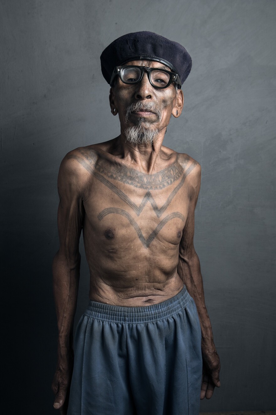 Pennga, 82, displays his chest tattoo, etched onto young teenagers as a rite of passage into manhood.