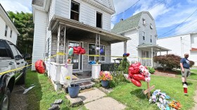Jay Conden stands at the home on Bennett St in Luzerne is the site of a fatal fire of a 15 year-old, community members have left toys and balloons in memory of the boy.