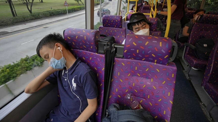 Passengers sleep on the upper deck of a double-decker bus in Hong Kong on Saturday.