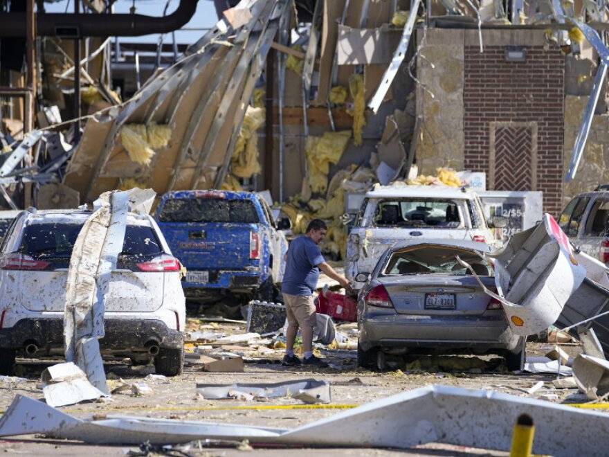 A man looks at a damaged car after a tornado hit the day before Sunday, May 26, 2024, in Valley View, Texas. Powerful storms left a wide trail of destruction Sunday across Texas, Oklahoma and Arkansas after obliterating homes and destroying a truck stop where drivers took shelter during the latest deadly weather to strike the central U.S.