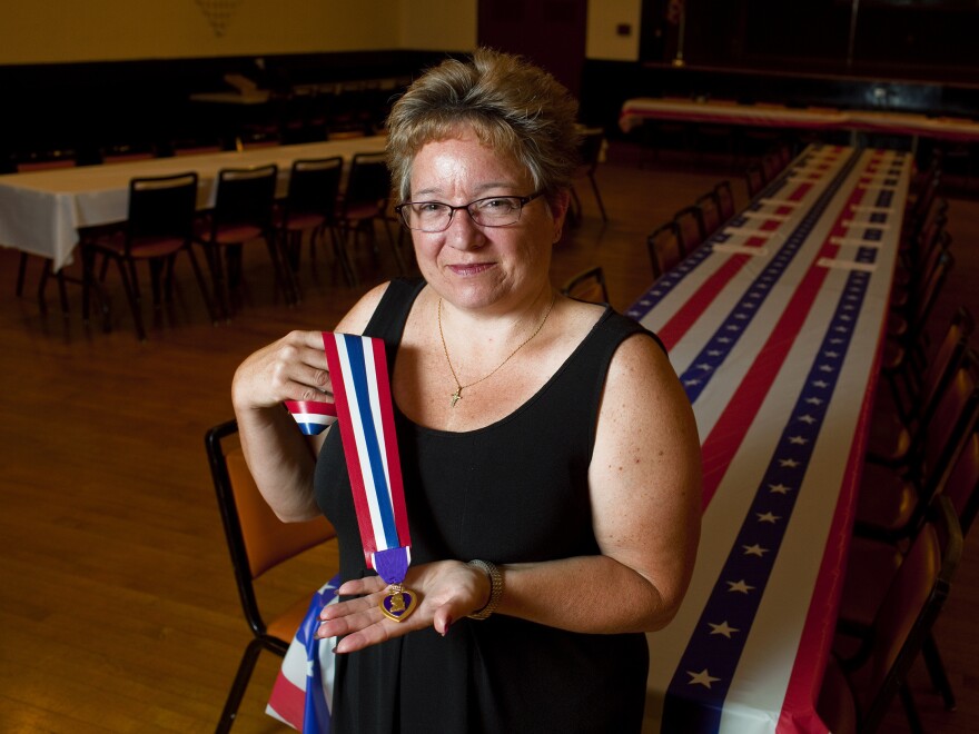 Retired Army Major Michelle Dyarman holds the Purple Heart medal she was awarded after suffering a severe concussion from an IED in Baghdad in 2005.