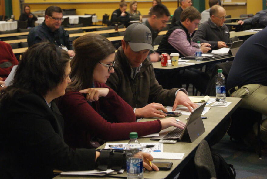 (Left to right) Kayla Holscher, Jenna Lansing and Andy Hruby work as a group during the Ag Survivor simulator activity at Purdue University's Top Farmer Conference.