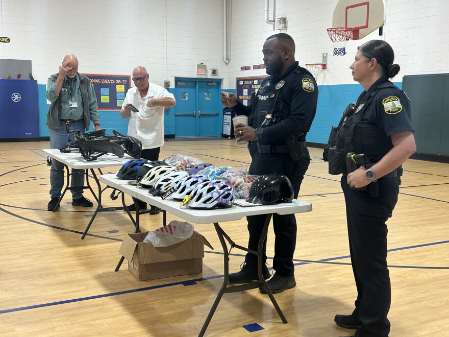 Officers with the Virginia Beach Police Department give out free helmets after an e-bike safety talk with families and youth at Cooke Elementary School on Sept. 26, 2026.