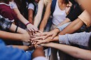 Multicultural teenagers putting their hands together in a huddle. Group of unrecognizable young people expressing their unity and teamwork.