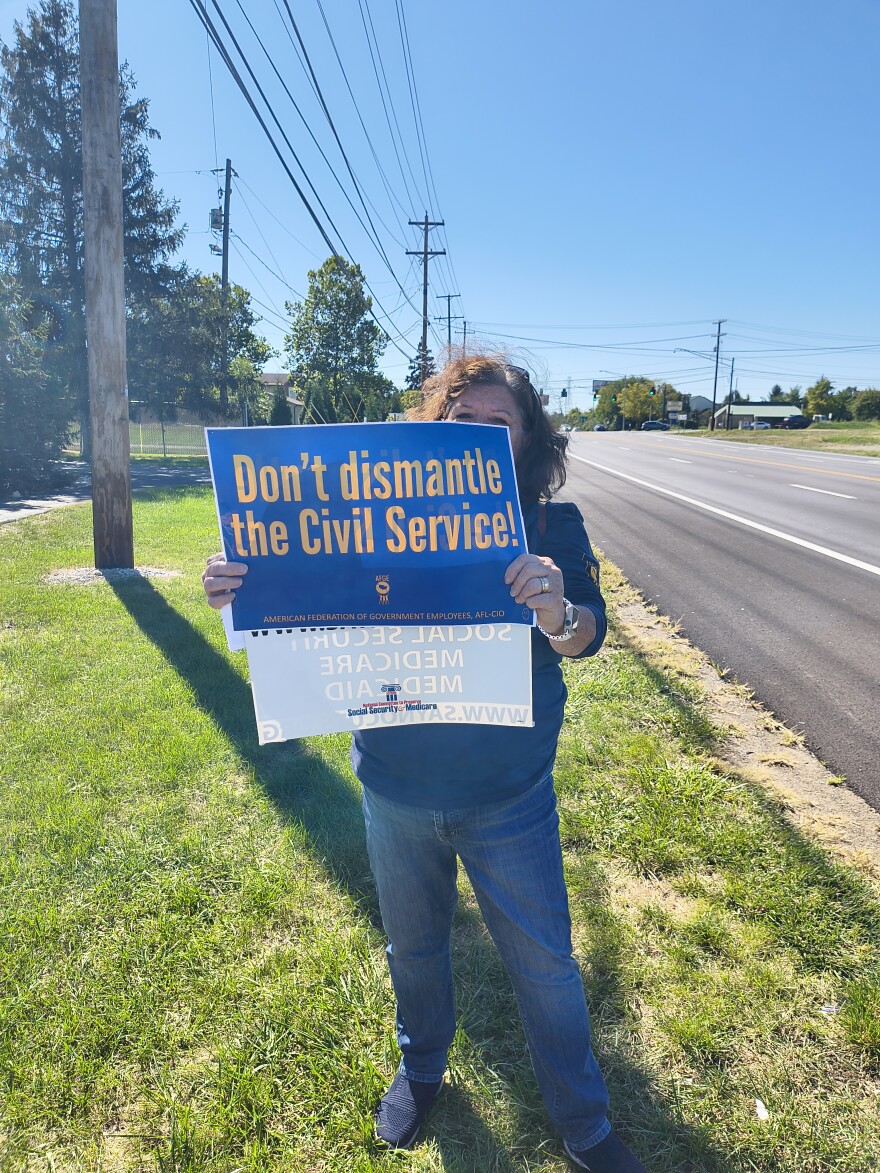 Retired social security administration worker Patti Davis-Sato holds a sign outside of the SSA office on Georgesville Road. She's protesting the government shutdown. She represents unionized workers at AFGE Local 3448.