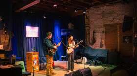 Two musicians perform onstage.