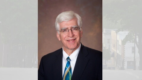 A man in a suit, tie and glasses