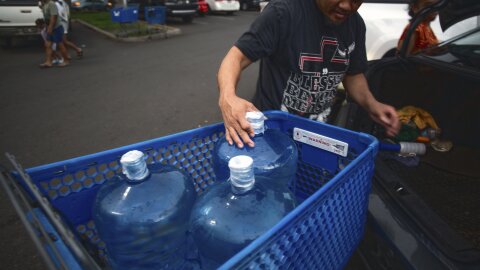 Washington state resident Poppy Mellon fills his car with jugs of water in preparation for the tsunami threat at the Kapolei Walmart, Hawaiʻi, Tuesday, July 29, 2025.
