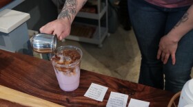 A barista at 108 Vine in Gainesville, Florida pours an espresso shot over an ube latte. (Kristin Moorehead/WUFT News)