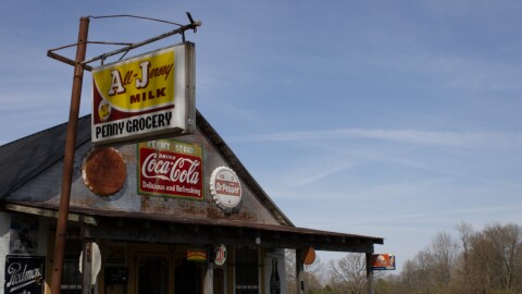 The exterior of the Penny Grocery Museum, covered in vintage signs.