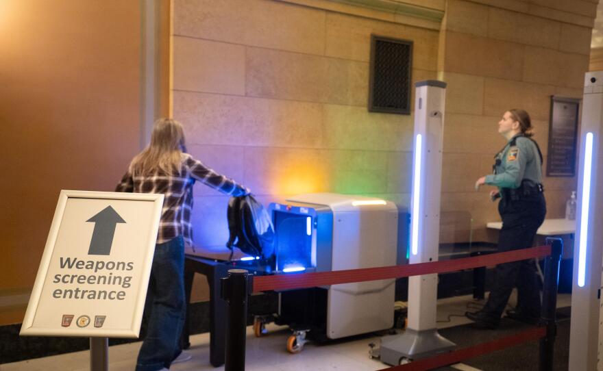 A visitor to the Minnesota State Capitol places a backpack into a scanner on Feb. 19, 2026. New in 2026, visitors are required to go through metal detectors.