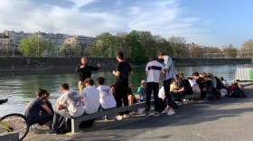 Young people gathered Wednesday by the Seine River in Paris, largely without masks and without social distancing. French President Emmanuel Macron has ordered the country into a third lockdown because of the continued spread of COVID-19.