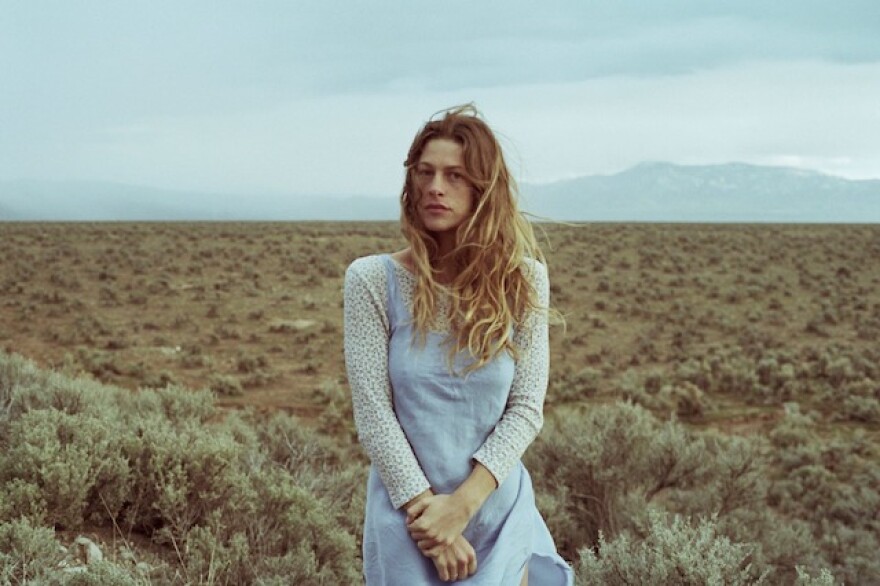 Indigo Sparke, standing in a field, with a mountain in the distant background